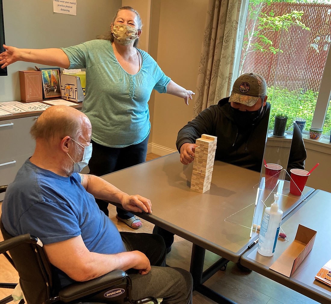 Left to right: ElderPlace participants Jeffrey Hewitt and Betty Jackson enjoy spending time with Providence ElderPlace food service aid Ethan Cha. [Betty is standing; Jeffrey and Ethan are sitting].