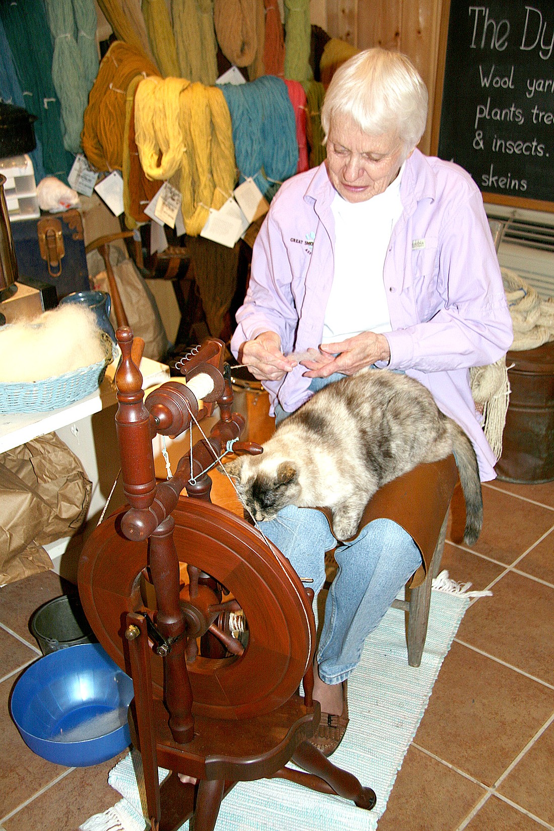 Bette Raymond demonstrates how to use a spinning wheel (with the help of Marble the cat) at Cliff Dwellers Gallery.
Photo courtesy of the Gatlinburg Convention and Visitors Bureau