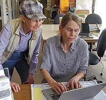 Seattle Genealogical Society volunteer Christine assisting a client