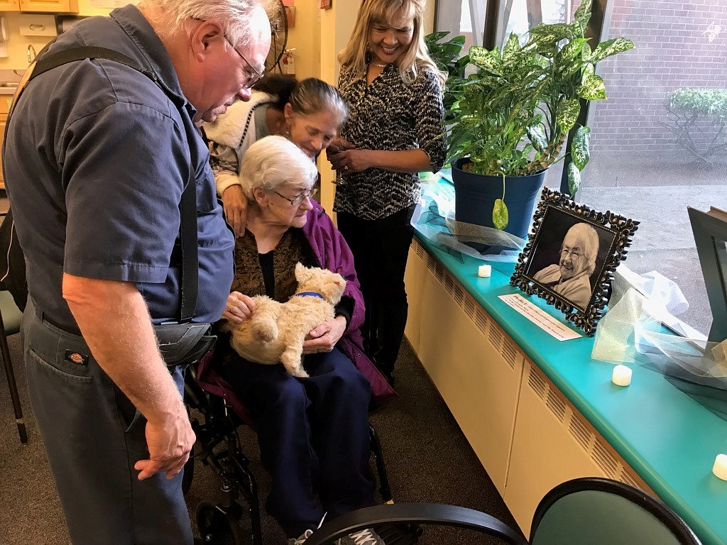 The family of Providence ElderPlace participant Phyllis Frost show Phyllis her photo, which was included in the Portraits of Providence ElderPlace exhibit that debuted Oct. 18, 2018, at Providence ElderPlace West, which is housed at Providence Mount St. Vincent