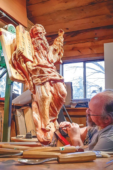 Dale Woodard with his relief carving of Moses, one of his seven Biblical carvings installed at a Tacoma church