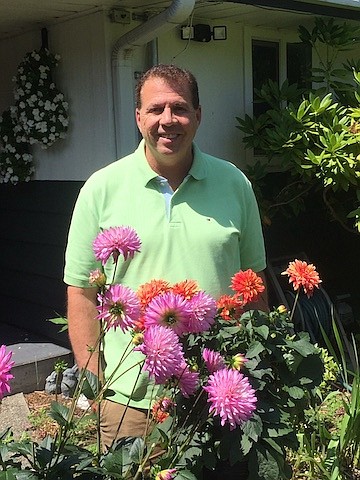 John Schieszer, Northwest Prime Time's Medical Minutes columnist, pictured with a few of his dahlias. "When cut, the flowers produce new ones immediately. It is like magic,” he says.