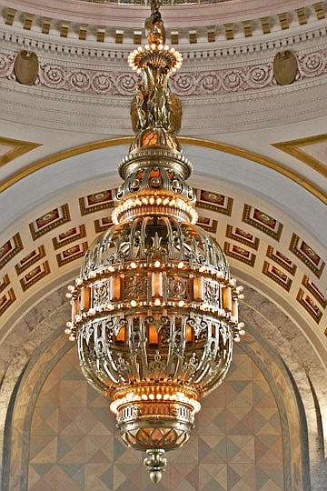 The largest chandelier ever designed by the Tiffany Studios of New York is installed in Washington State's Legislative Building in Olympia. Go to the fourth-floor balcony for the best view. Rising 175 ft. above the rotunda floor, this bronze chandelier weighs five tons (10,000 pounds) and is decorated with 204 light bulbs. Featuring elaborate Greco-Roman stylized figures, the chandelier is supported by a 101-foot-long chain that itself weighs 3,000 pounds. The chandelier arrived by train and was assembled on the Rotunda floor in 1928.