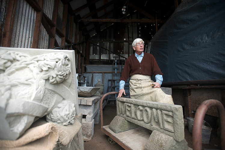 Surrounded by intricately carved pieces of sandstone, Keith Phillips, a master stonecutter, stands inside a rustic shed in downtown Tenino. Photo courtesy Pete Caster/ Chronicle file photo.