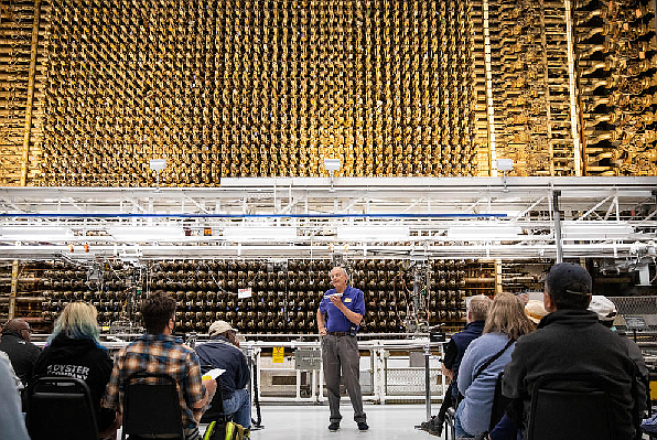Visitors listen to guide Rick Bond as they stand before the front face of the plutonium reactor at the Hanford site on Wednesday, Oct. 12, 2022. The B Reactor was the first full-scale plutonium production reactor in the world. (Amanda Snyder/Crosscut)