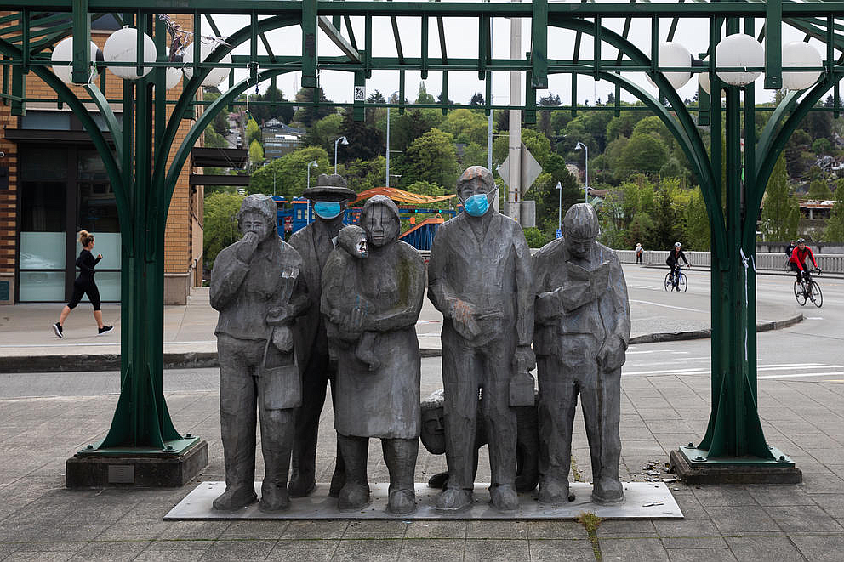 Fremont's beloved piece of public art, "Waiting for the Interurban," was dressed up with face masks in April 2020. (Matt M. McKnight/Crosscut)