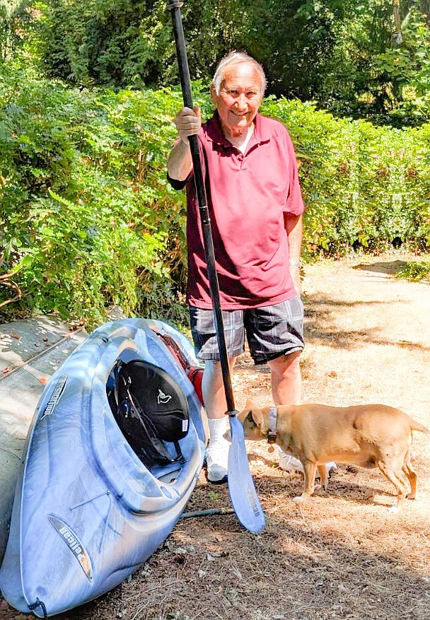 Roger Urbaniak with his new kayak and Sparky the dog looking on with curiosity