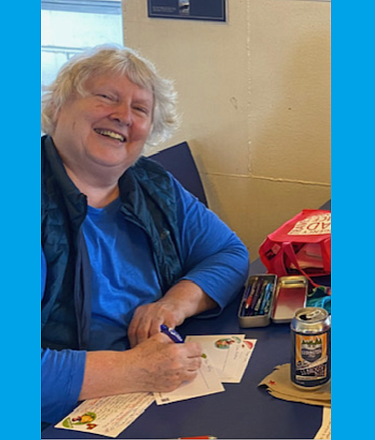 76-year-old Seattleite, Eileen MacIntyre, is part of a group of volunteers who write postcards to voters to remind them to register and of upcoming elections. Photo by John Schieszer.