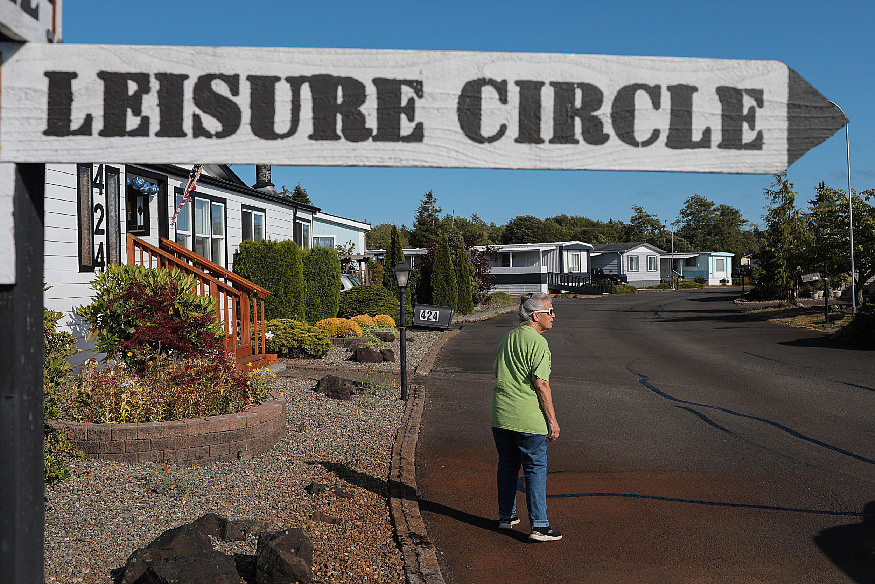 Judie Short walks through the Leisure Manor Estates neighborhood, July 21, 2023. Short’s mother moved into the park in the 1980s and Short has lived there for the past five years. (Genna Martin/Crosscut)