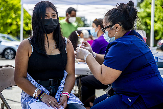 Jacqueline Alvarado, 14, receives a vaccine during a clinic for students and families at Tyee High School on June 4, 2021. Alvarado came to the clinic with her aunt, who also got vaccinated, and her father, sibling and cousins. (Dorothy Edwards/Crosscut)