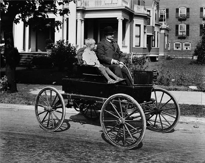 Ralph Hopkins (right) with 1900 Woods Electric automobile, Seattle, ca. 1916. This photo is courtesy of MOHAI (1983.10.10334).