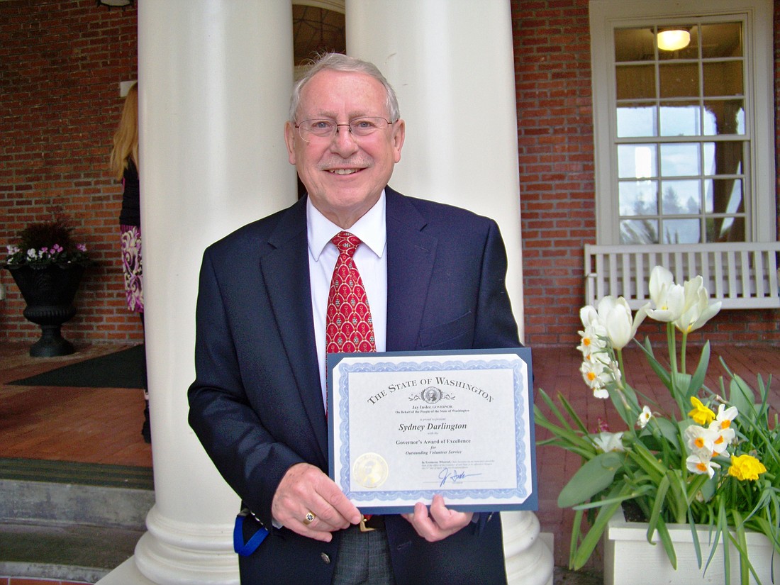 Syd Darlington displays his certificate at the Governor's Mansion in Olympia.