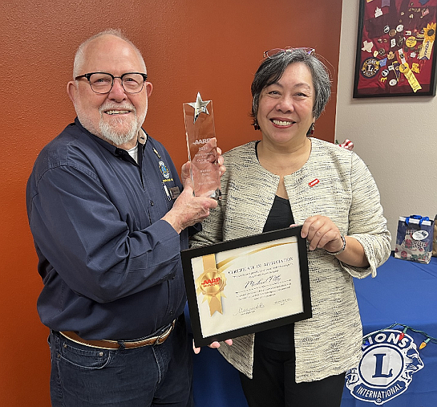 Michael Petty (left) receiving the statewide award for community service, the Andrus Award, from AARP Washington State Director Marguerite Ro (right)